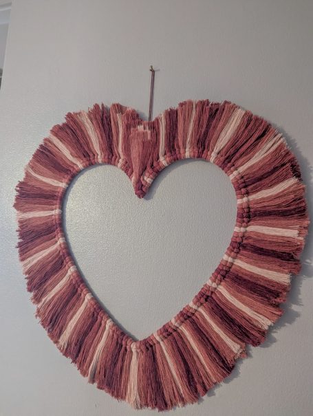Heart-shaped decorative frame with ruffled, multi-toned fabric.