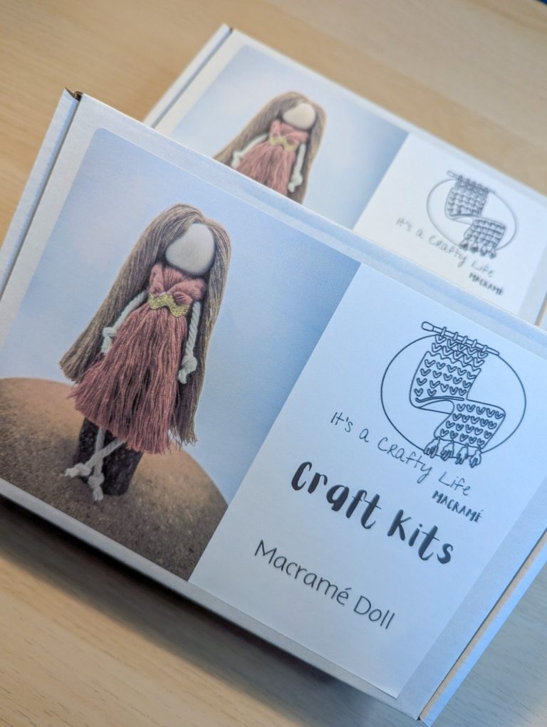 A craft kit box featuring a doll with long hair and a dress, labelled "Macrame Doll".